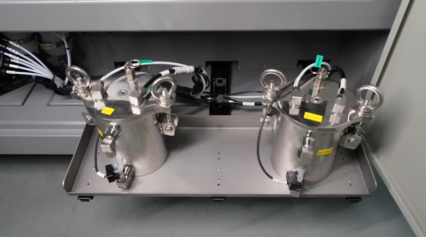 Dois tanques de pressão constante em aço inoxidável, para fluxo e solvente de limpeza, na gaveta inferior da máquina